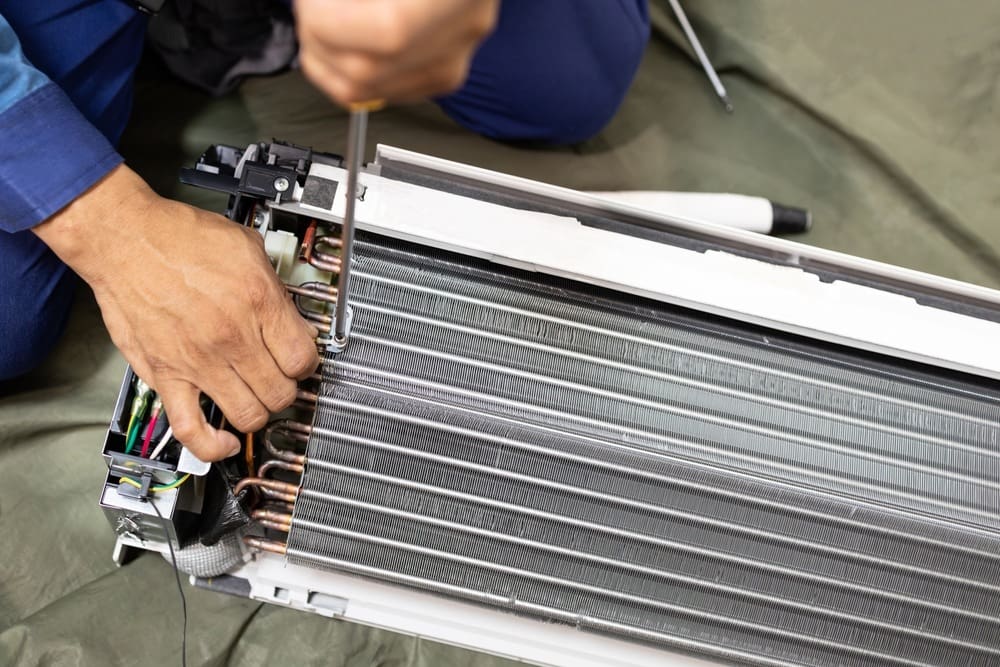 Technician is fixing or checking the evaporator system, troubleshooting air conditioning unit