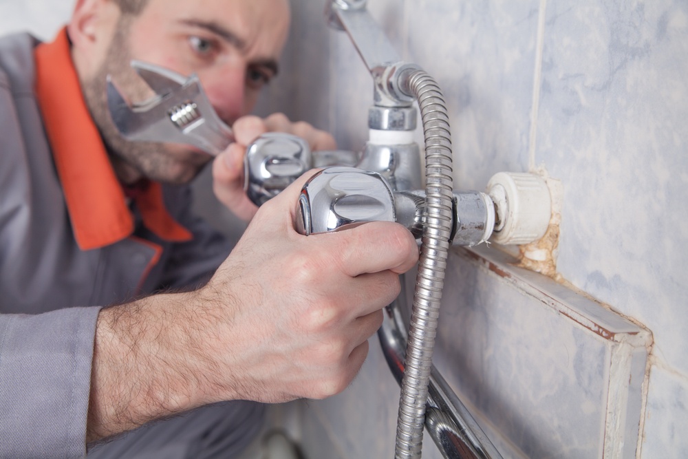 technician fixing shower faucet